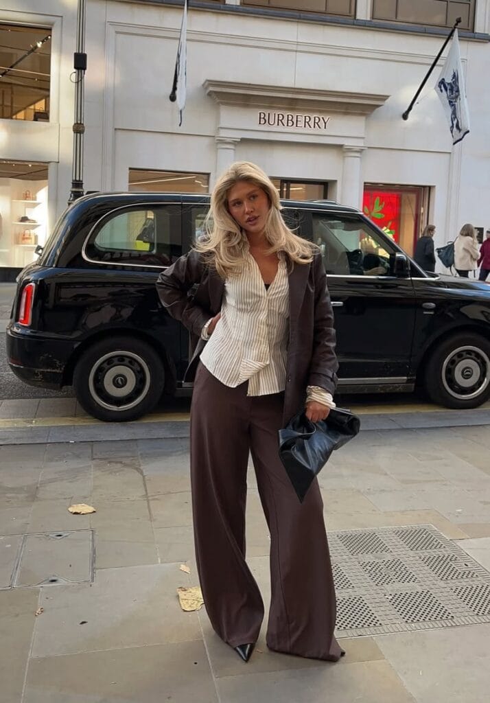 Chic fall outfit with brown leather jacket, brown trousers, and striped shirt
