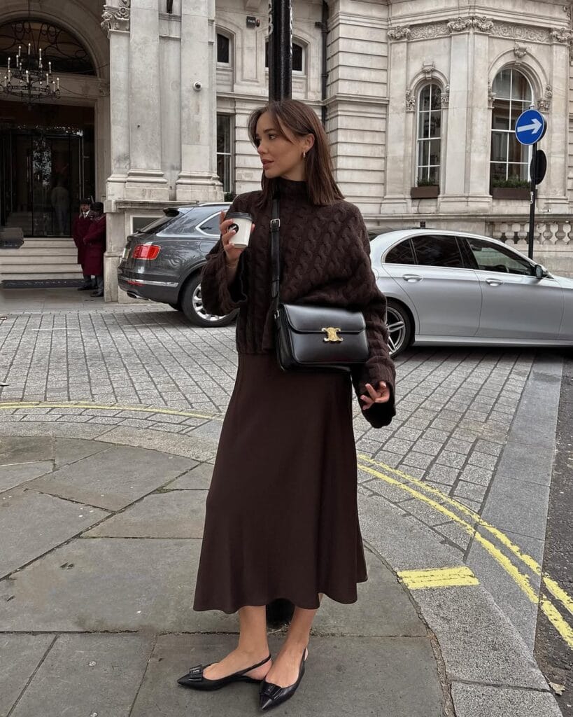 Fall outfit with brown cable knit sweater, chocolate midi skirt, and pointed flats