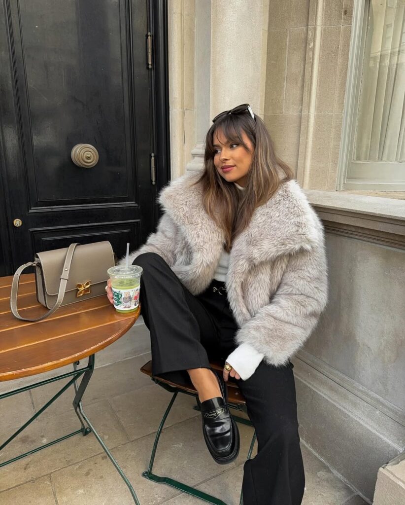 Classy fall outfit with grey faux fur jacket, black trousers, white shirt, and black loafers