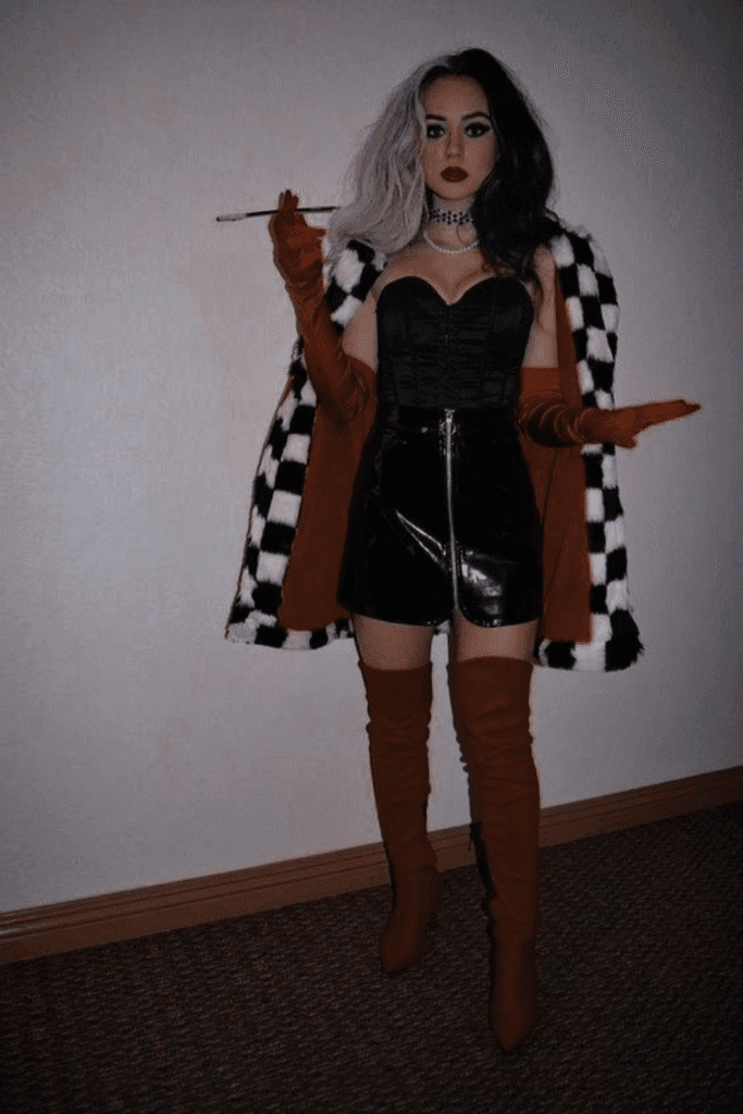 Cruella de Vil Halloween costume with black and white wig, faux fur coat, red gloves, and black corset—a bold villain look for Halloween.