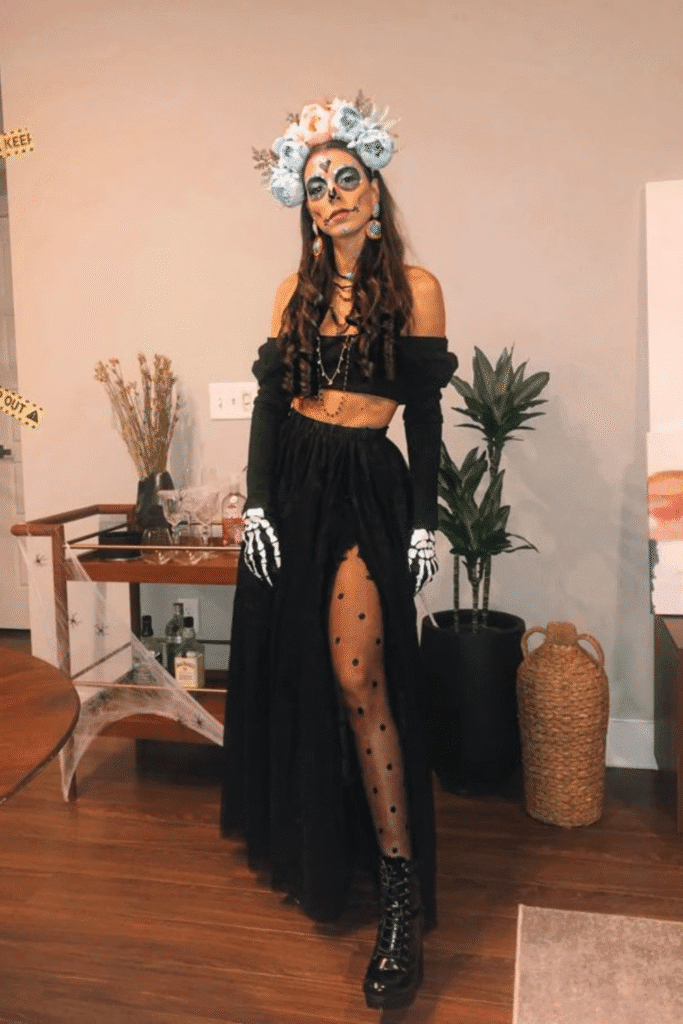 Día de los Muertos Halloween costume with black off-shoulder set, flower crown, and skeleton makeup—a stunning and bold party look.