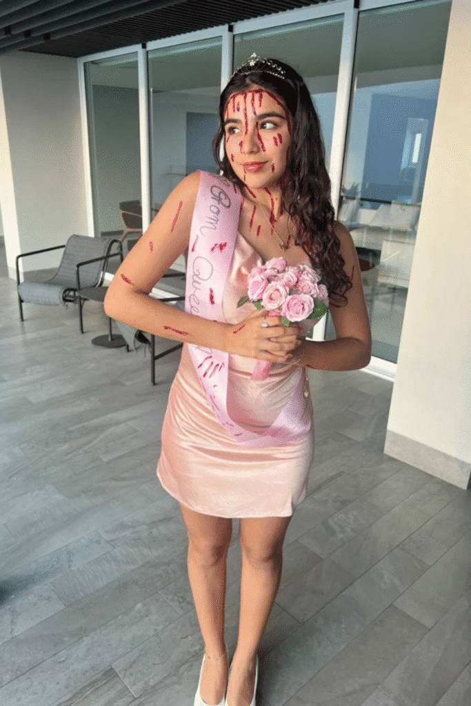 Carrie prom queen Halloween costume with pink dress, sash, tiara, and fake blood—a classic horror movie party look.