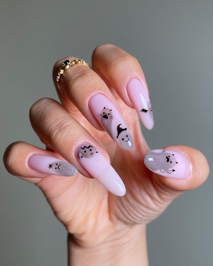  Pale pink Halloween nails with minimal black doodle art: ghosts, cats, bats on almond nails.