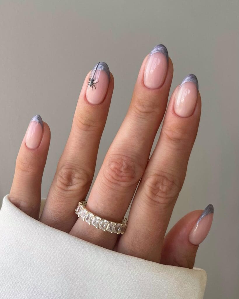 Smoky lavender French tips with small spider accent on almond-shaped Halloween nails.