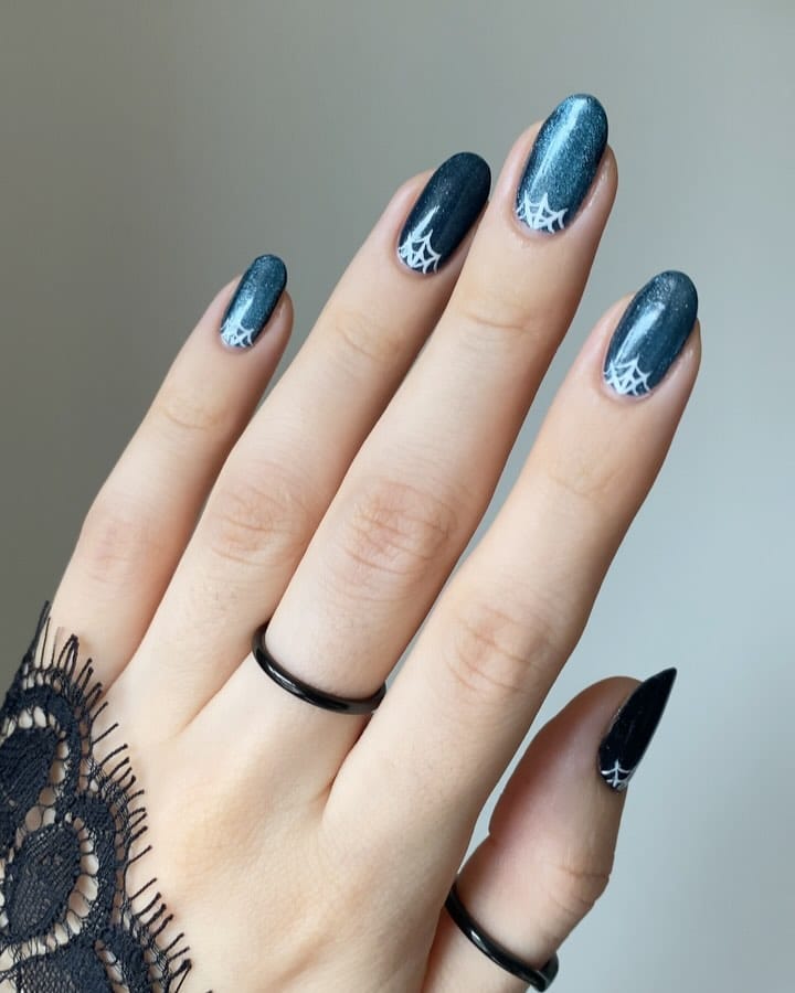 Teal shimmer Halloween nails with white spiderweb accents and black lace for a spooky vibe.
