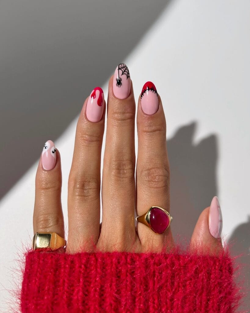 Pink Halloween nails with red drip, spiderweb, ghost, and stitched art on almond nails.