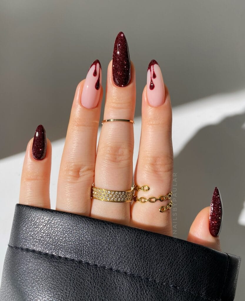 Wine red glitter Halloween nails with blood drip art on almond shape.