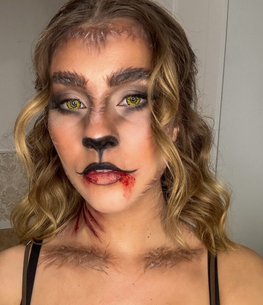 Wolf-inspired Halloween makeup with yellow eyes, faux fur effects, and bloody scratch marks