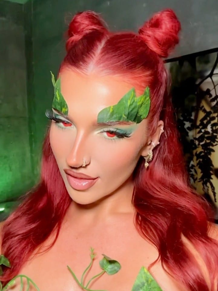 Halloween makeup with leafy green eyebrows and red hair for a Poison Ivy-inspired look.