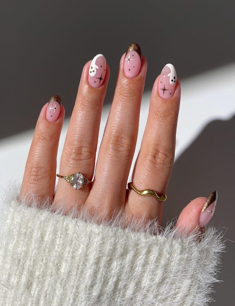 Bronze French tip Halloween nails with ghosts and star accents on almond shape.
