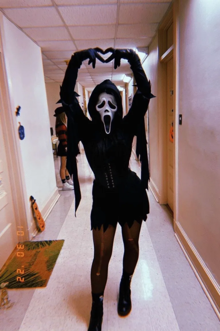 Halloween costume with black corset, Ghostface mask, and playful pose, a cute and spooky twist on the classic Scream Halloween look.