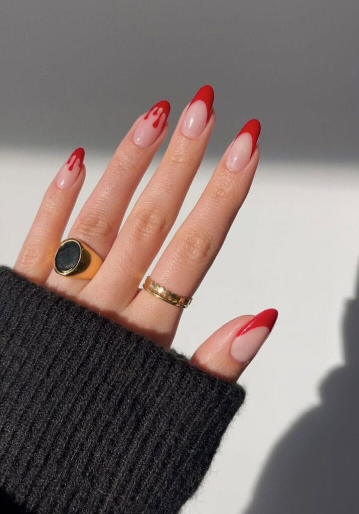 Red French tip Halloween nails with matte finish and blood drip art on almond shape.

