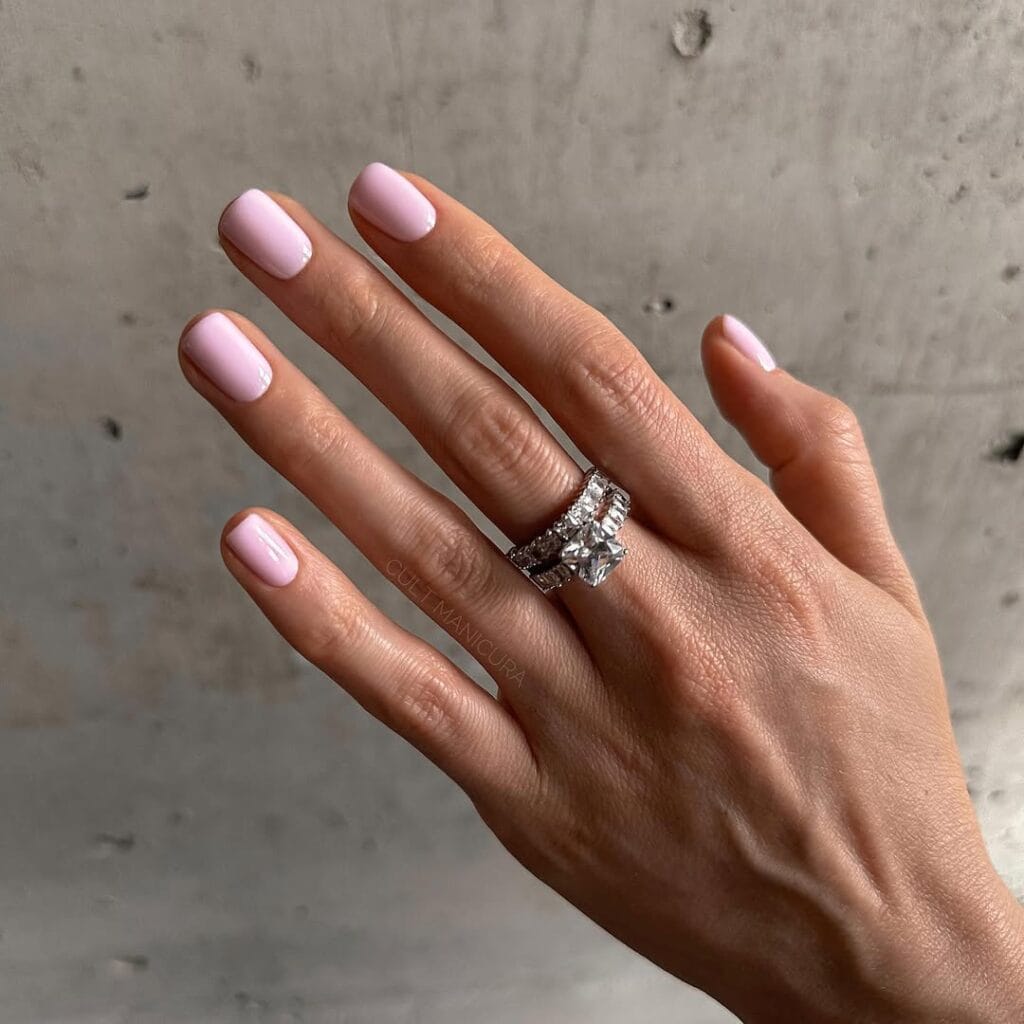 Light pink old money nails with glossy finish, styled with diamond rings, elegant and minimal manicure.
