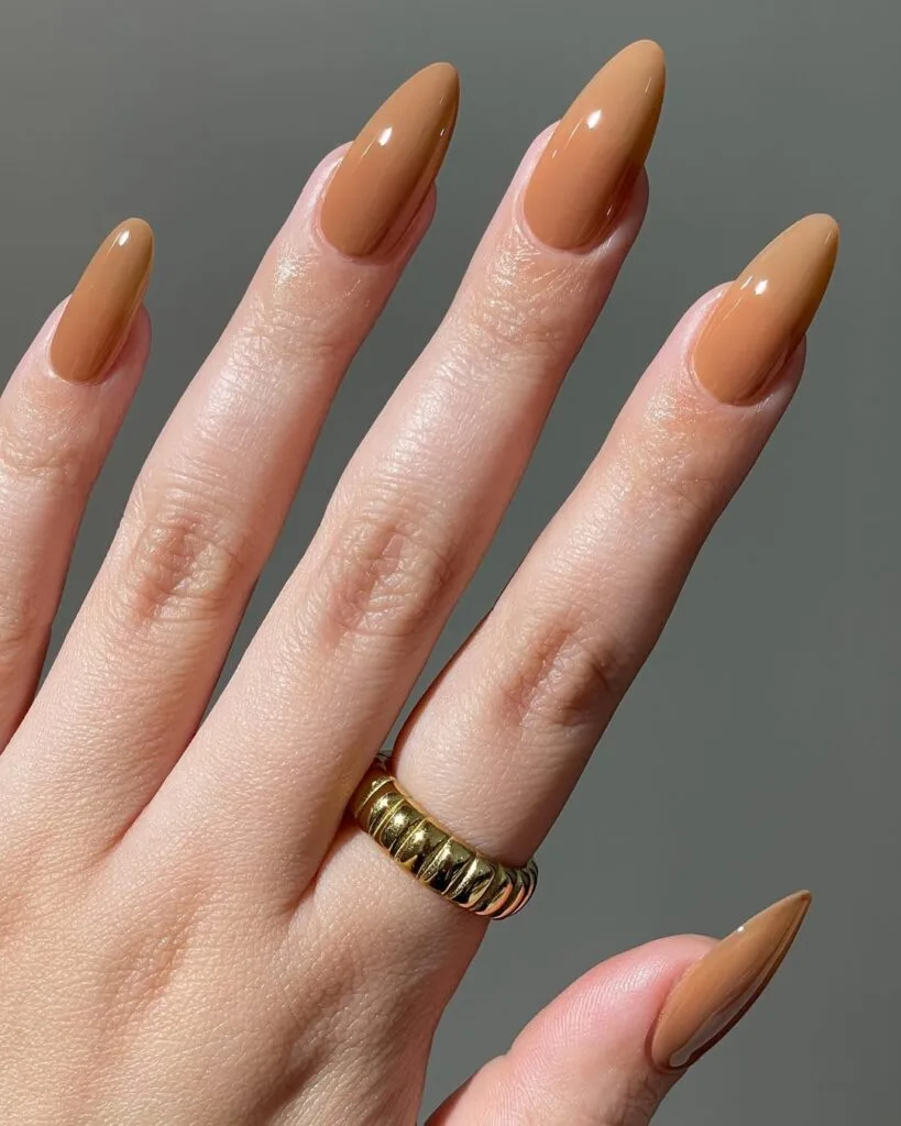 Almond neutral nails, rich caramel brown, glossy and warm fall-inspired manicure.