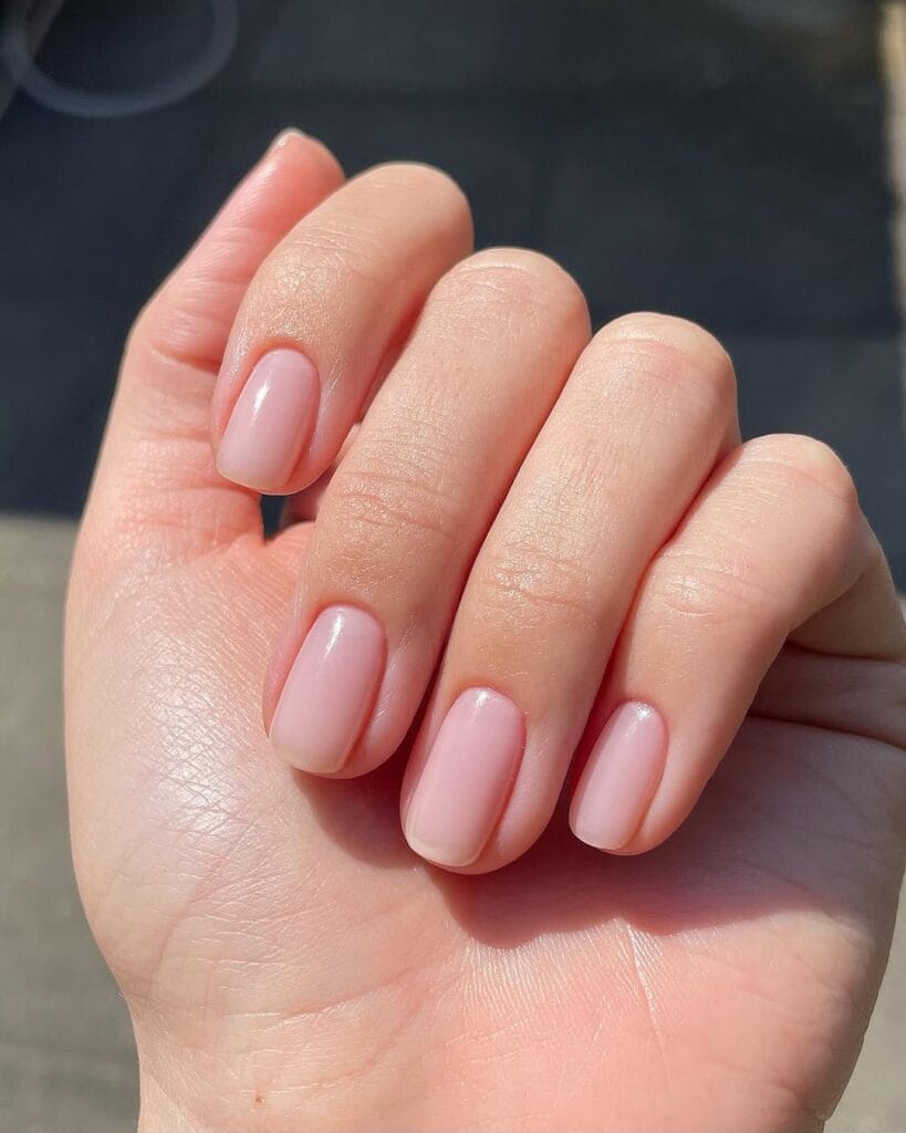 Short natural soft pink neutral nails, squoval shape, subtle and clean look.
