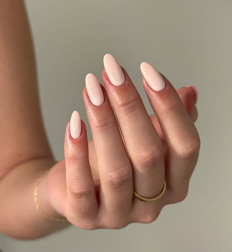 Creamy blush nude neutral nails, almond shape, glossy, elegant, and versatile.
