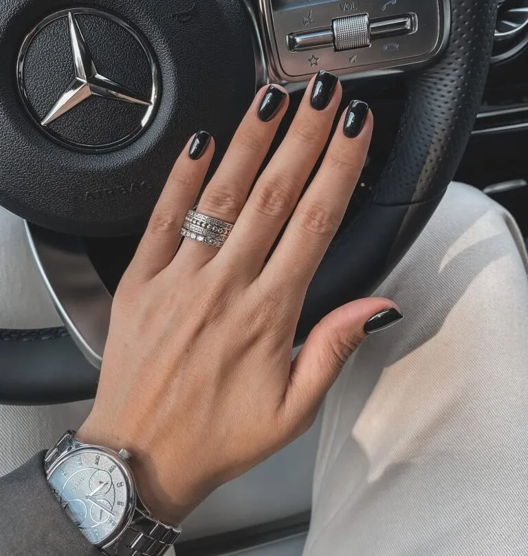 Glossy black old money nails on a hand with silver rings and luxury watch, powerful and sleek look.