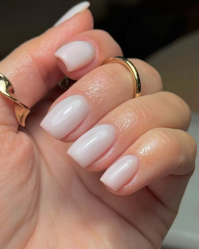 Soft white neutral nails, short square shape, milky translucent finish, fresh and clean style.