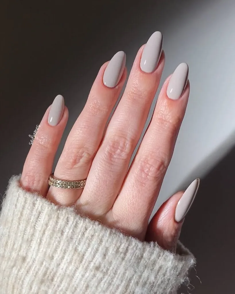 Taupe neutral almond nails, cashmere finish, glossy, styled with cream knit sweater.