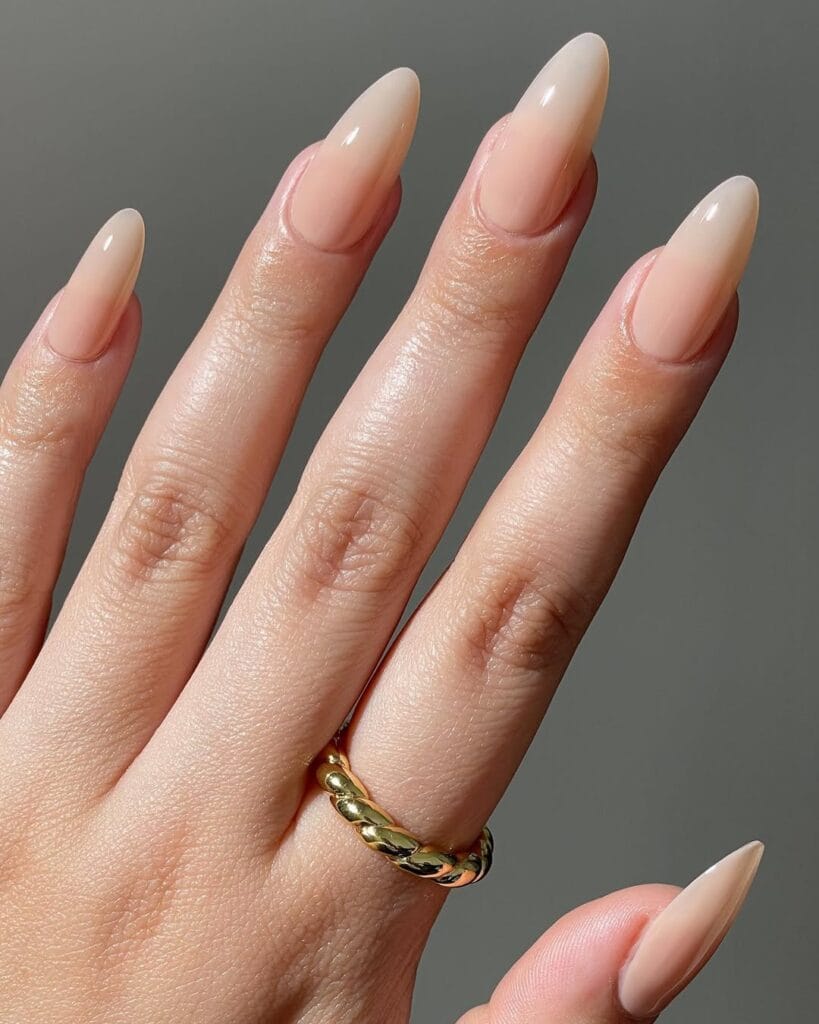 Almond shaped neutral nails, latte beige fade, glossy, and elongated minimalist style.
