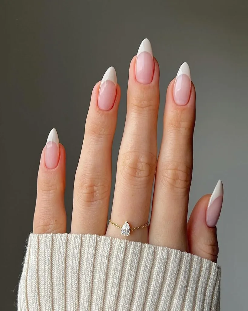 Almond-shaped old money nails with crisp white French tips, elegant and timeless manicure.