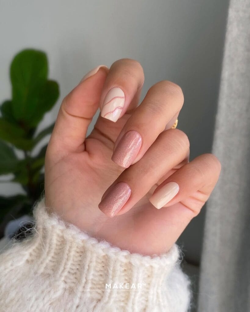 Nude neutral nails with shimmer, swirl accent, and creamy beige mix, modern and playful.
